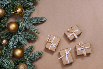 Fir branches with christmas decorations and gifts on kraft paper background