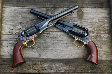 Black powder revolvers on an old board. - obrazy, fototapety, plakaty