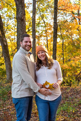 Fall portrait of young couple expecting a baby