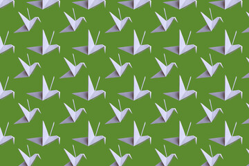 Seamless background with paper cranes. White paper birds on a plain background. Crafts from paper with children. Classic origami. 