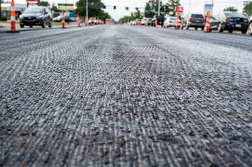 Low angle shot across a scarified street under construction with lanes on either side blocked off.