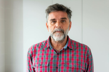 Obraz premium Isolated shot of senior handsome male with beard, mustache, trendy and hairdo. Relaxed with serious expression on face. Simple and natural looking at the camera.