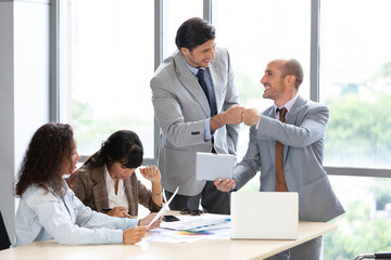 two businessmen giving fist bump for success works and after complete a deal in meeting room