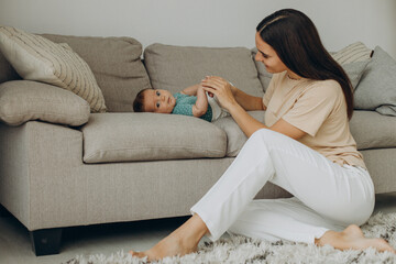 Mother with baby girl on sofa at home