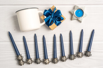 Jewish holiday Hanukkah white mug mock-up with menorah, gift box and candles, Top view from above. Flat lay, copy space.