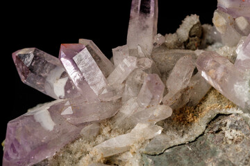 Macro mineral stone Amethyst crystals in rock on a black background