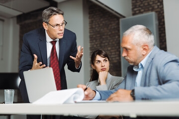 Furious boss shouting at his colleague during a business meeting in the office