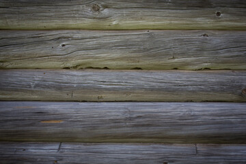 Obraz premium Wooden logs of an old house. Close-up. Weathered natural gray wood texture. Background. Horizontal photo