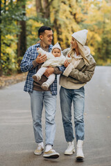 Young family with little daughter in autumn park