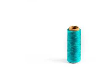 A coil of aqua thread. Spool of colored threads on a white background. Waxed sewing thread for leather crafts.
