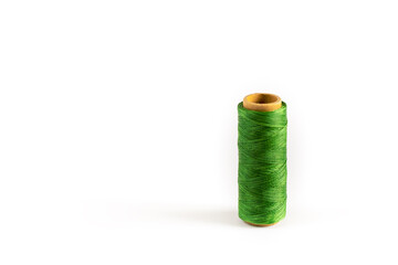 A coil of green thread. Spool of colored threads on a white background. Waxed sewing thread for leather crafts.