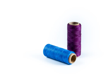 A skein of purple and blue thread. Coils of colored threads on a white background. Waxed sewing thread for leather goods.