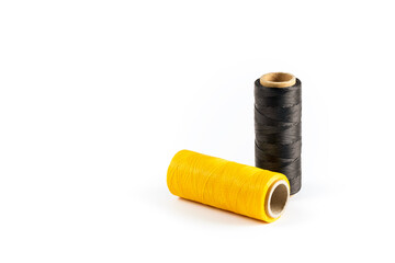 A skein of black and yellow thread. Coils of colored threads on a white background. Waxed sewing...