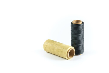 A skein of black and beige thread. Coils of colored threads on a white background. Waxed sewing...