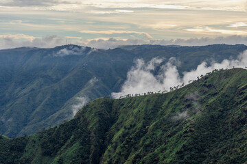 mountain valley with dramatic sunset sky and low clouds at evening