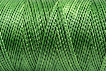 A coil of green thread. Spool of colored threads on a white background. Waxed sewing thread for...