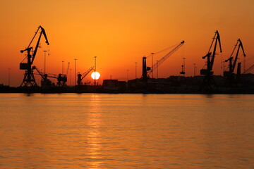 Fototapeta na wymiar cranes in port at sunrise
