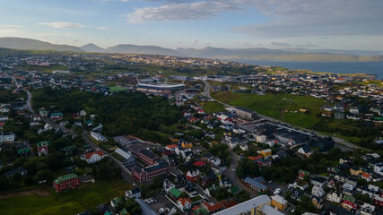 Beautiful aerial view of the City of Torshavn Capital of Faroe Islands- View of Cathedral, colorful buildings, marina, suburbs and Flag