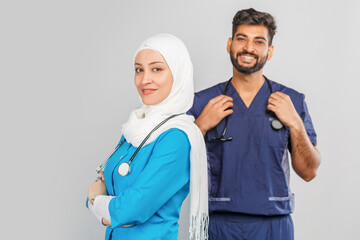 professional muslim doctor woman and indian assistant discuss tasks. portrait of beautiful medical workers with stethoscopes