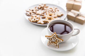 Cup of coffee with gingerbread christmas cookies in the form of stars on a white table. Copy space