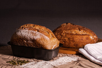 Bakery - Breads on a kitchen surface with seeds and wheat flour. Vintage kitchen scene. Healthy food.