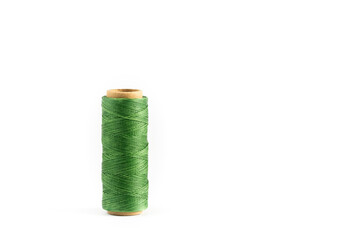 A coil of green thread. Spool of colored threads on a white background. Waxed sewing thread for leather crafts.