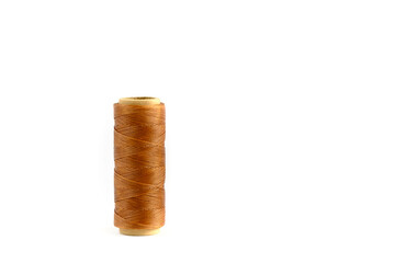 A coil of brown thread. Spool of colored threads on a white background. Waxed sewing thread for leather crafts.