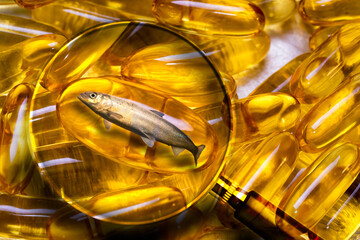 Magnifying glass zooms in on the omega3 capsule with a live fish inside. Concept of how to choose omega3. Choosing the best natural fish oil. 