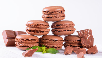 Macaroons with Sweet Chocolate and Coffee Beans on White Wooden Table