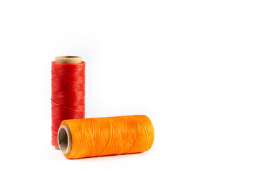 A skein of red and orange thread. Coils of colored threads on a white background. Waxed sewing...