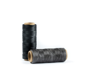 A skein of black and gray thread. Coils of colored threads on a white background. Waxed sewing...