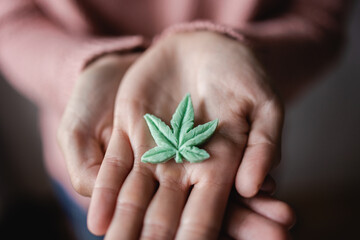 Cbd candy - Hands holding edible cannabis leaf for anxiety treatment - Marijuana alternative...