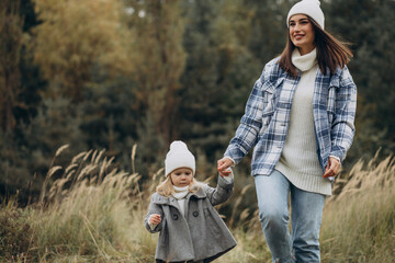 Mother with little daughter together in autumnal weather having fun