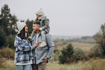 Family with little daughter together in autumnal weather having fun