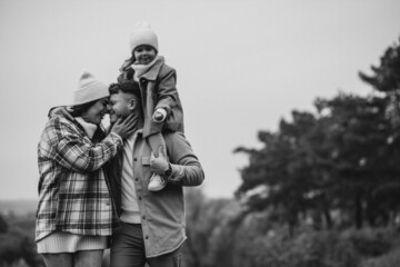 Family with little daughter together in autumnal weather having fun