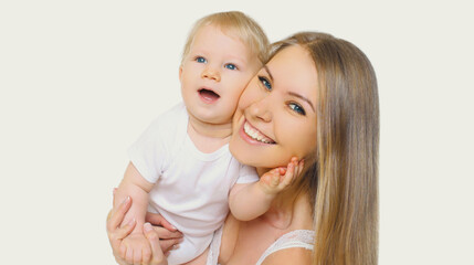 Portrait of happy cheerful smiling mother and baby playing together on a white background