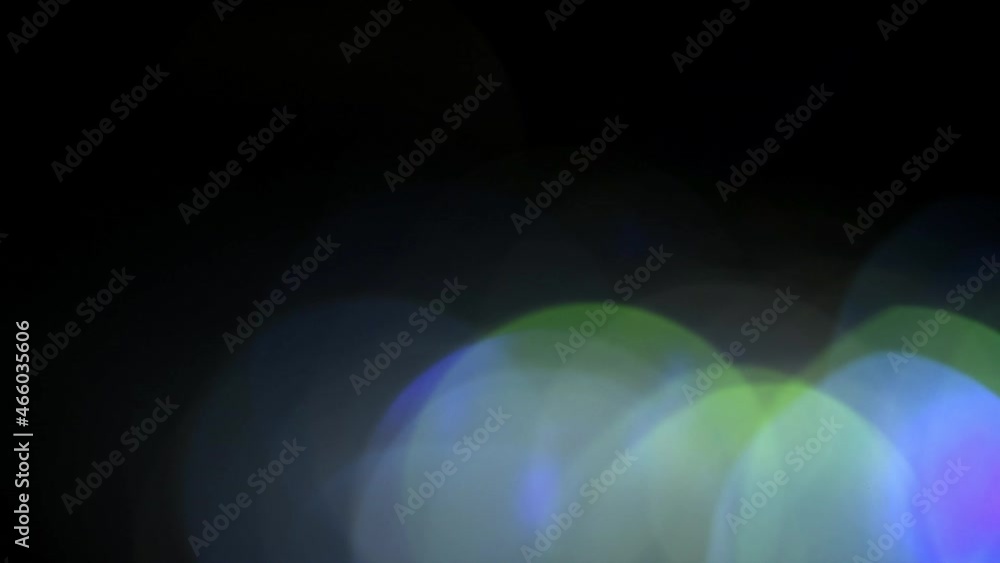 Wall mural sparkles of blue and green large bokeh on a black background. round bokeh rolls with gradient along 
