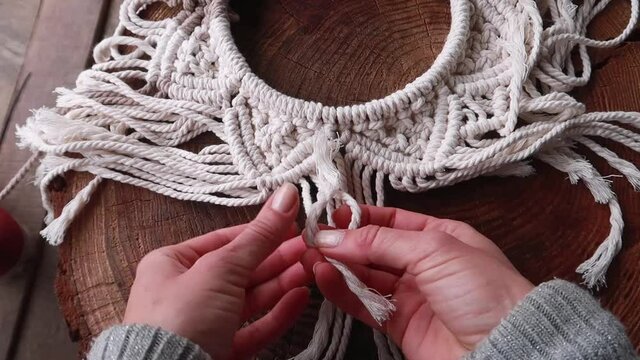 People hobby. A woman weaves with her own hands a pattern of Macrame threads for decoration or home decor. Home decor idea handmade Macrame cotton. 