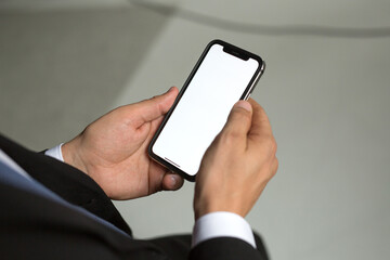 businessman man in a jacket and suit holds a smartphone in his hands. Electronics are in human hands. Concept - digital era