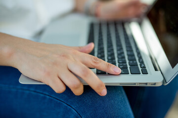 businessman girl in jeans and a white blouse holds an open silver laptop in her hands. Technologies in financial sphere. Concept - Digital era