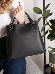 black backpack bag with straps on girl's back. bag for things, accessories and textbooks. Leather backpack with locks.