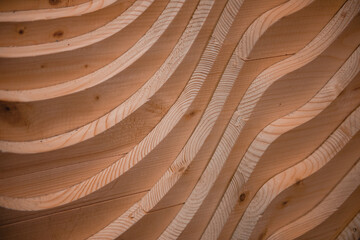 Wavy cut lines with the effect of sand dunes or sea waves on the surface of pine board.