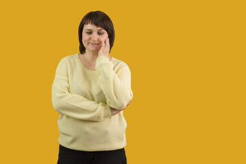 woman sadly stands on yellow background