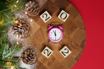 New Year's creative composition for 2022. On a wooden background with snow and and pine cones.
