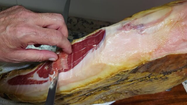Slicing a typical Iberian ham or Jamon Serrano from Spain