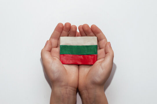 Bulgarian flag made of plasticine in the hands of a child on a white background