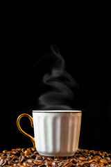 On a black background, a cup of hot aromatic coffee on coffee beans.