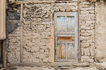 Fototapeta na wymiar Wooden door in a traditional mud brick home.