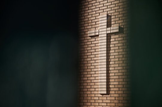 Brick cross on the temple wall. Dark free space for a text on a religious theme