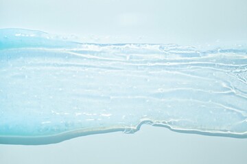 Fototapeta na wymiar Cream gel transparent cosmetic sample texture on blue background